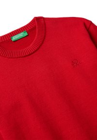 Roter Rundhals-Pullover mit geripptem Kragen, grünem United Colors of Benetton-Label und dezent gesticktem "9K"-Logo auf der Brust.