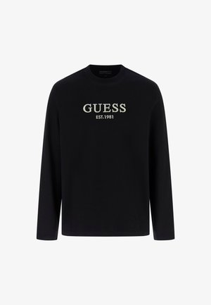 Črna majica z dolgimi rokavi, opremljena z vezenim logotipom "GUESS EST.1981" v svetlo sivi barvi. Izdelana je iz gladkega materiala, ima klasičen okrogli izrez in standardno prileganje.