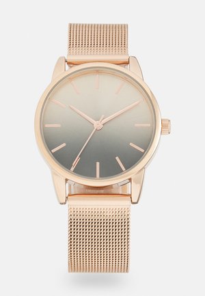 Roségoldene Armbanduhr mit Mesh-Armband, gradientem minimalistischen Zifferblatt und einfachen Stundenmarkierungen, die die Zeit 10:09:36 anzeigen.