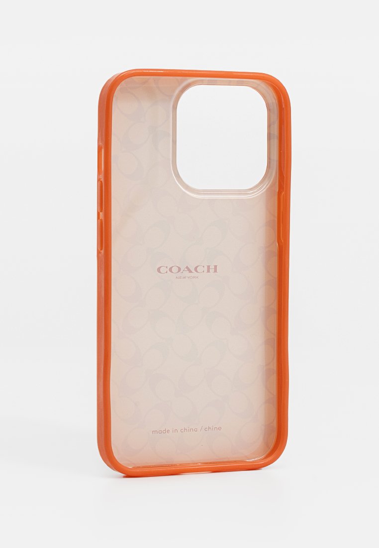 Coque de smartphone transparente avec bordure orange, présentant un motif circulaire subtil et la marque 'COACH'. Le matériau semble flexible et durable.