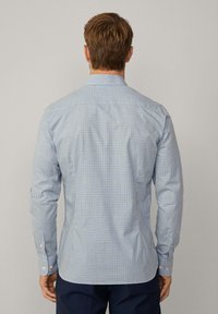 Camicia con bottoni aderente a maniche lunghe in tessuto di cotone, con motivo a scacchi blu e bianchi, polsini con un bottone e colletto classico.
