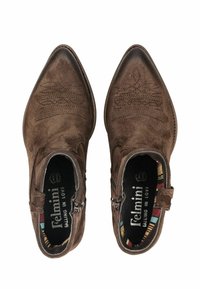 Brown suede ankle boots with pointed toes, decorative stitching, side zippers, and a colorful patterned lining. Surface appears soft and textured.