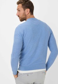 Hellblauer Pullover aus strukturiertem Strickmaterial, mit langen Ärmeln und Rundhalsausschnitt, versehen mit einem kontrastierenden weißen Saum.