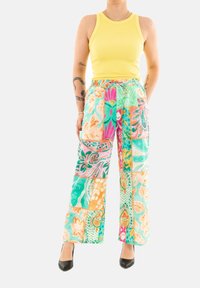 Pantalones de pierna ancha de patchwork multicolor con patrones florales y geométricos en tonos verde azulado, naranja, rosa y verde; tejido ligero con cordón de ajuste.