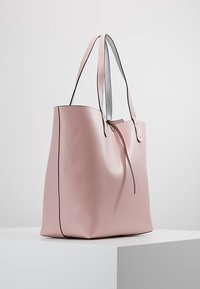 Roze leren schoudertas met een gladde textuur, voorzien van zwarte accenten en dubbele grijze banden, ontworpen in een minimalistische vorm.