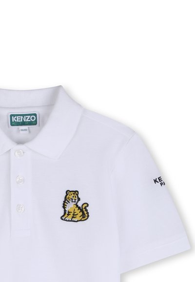 Polo blanco de Kenzo Kids con tres botones, un pequeño tigre amarillo bordado en el pecho y el texto del logo en la manga.
