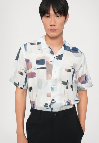 Camisa de manga corta con botones en una tela ligera. Base blanca con un patrón abstracto en azul, rosa y negro. También incluye un cuello.