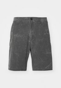 Shorts en denim gris avec une texture usée, dotés d'une fermeture à bouton à l'avant et de passants de ceinture, coupés au niveau des genoux, avec des détails de décoloration subtils.