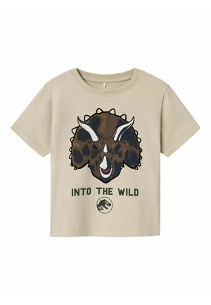 T-shirt beige a maniche corte con grafiche di un triceratopo, con il testo "INTO THE WILD" sotto e un logo circolare in fondo.