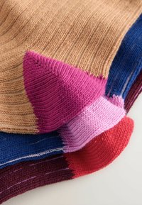 Multicolored knitted socks with ribbed texture; features shades of beige, pink, blue, burgundy, and red with contrasting toe sections.