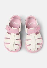 White and pink sandals with a woven design, adjustable strap, and rubber sole. Features CAMPer branding on insole. Lightweight material.