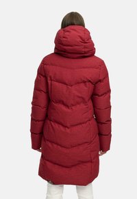 Czerwona kurtka puchowa z kapturem i pikowanym wzorem, z wysokim kołnierzem i bocznymi kieszeniami, wykonana z teksturowanej, trwałej tkaniny.