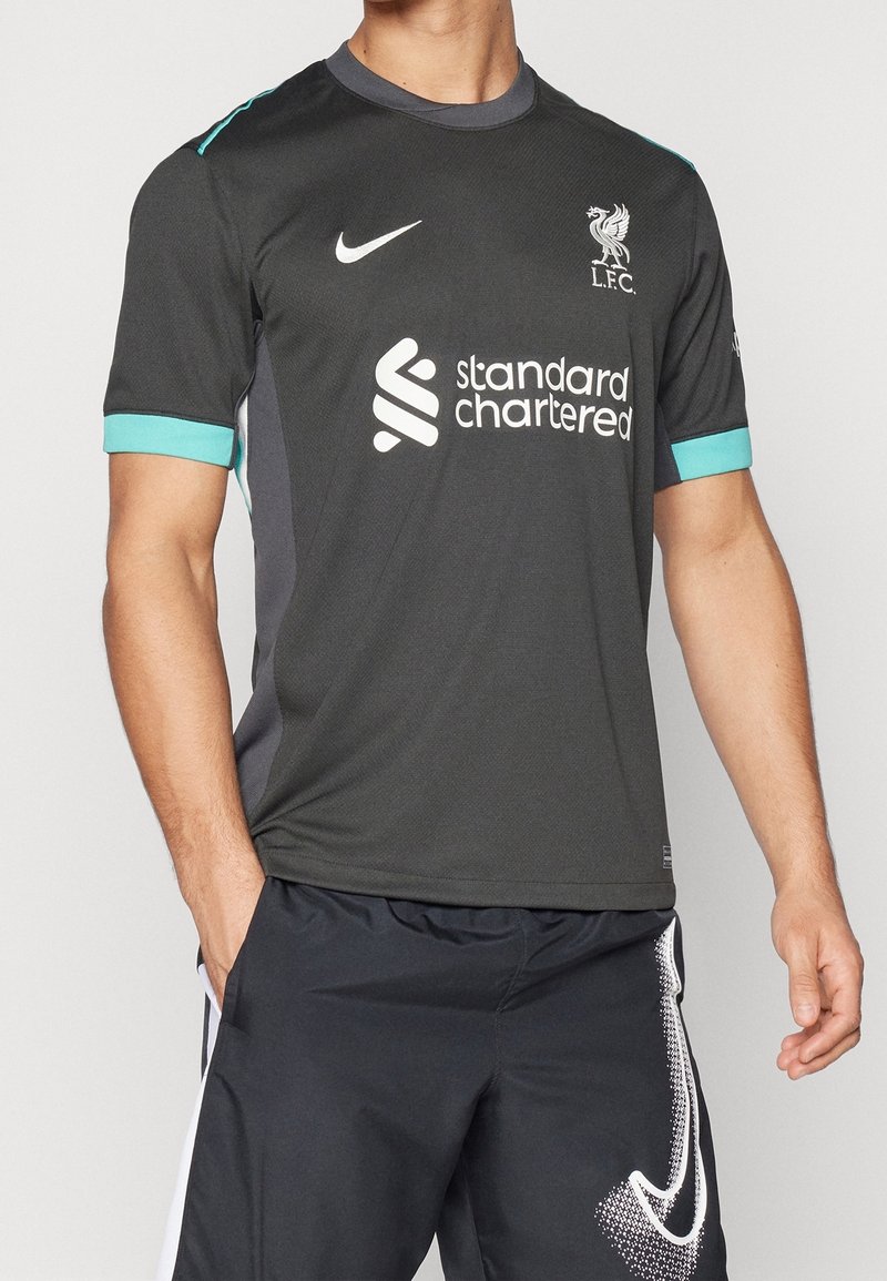 Musta Liverpool FC -paita lyhyillä hihoilla, jossa on turkooseja yksityiskohtia hartioissa ja hihoissa, esittää Nike-logoa ja sponsoritekstiä.