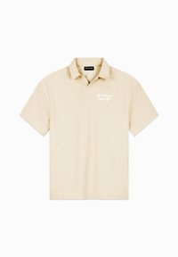 Korte mouw polo-shirt in licht beige met een gestructureerde stof. Heeft een kraag en een geborduurd wit logo op de borst.
