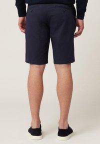 Marineblauwe shorts van een gladde katoenstof met een rechte snit. Voorzien van twee achterzakken met knoopsluitingen en een nette zoomlijn.