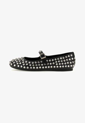 Chaussure plate noire Mary Jane avec une bride au niveau de la cheville, décorée de multiples clous en tone argent et de strass partout.