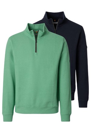 Twee sweatshirts met lange mouwen en een kwartritssluiting met een geribbelde textuur; één lichtgroen aan de voorkant, één donkerblauw aan de achterkant.