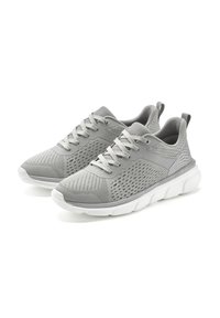 Graue Sportsneaker mit einem strukturierten Mesh-Obermaterial, kontrastierender weißer Sohle und Schnürverschluss, ausgestattet mit Perforationen zur Belüftung.