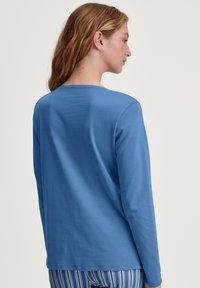 Lange mouwen overhemd in lichtblauwe katoen, met een ronde halslijn en een relaxte pasvorm, met een gladde textuur. De achterkant is zonder patronen.