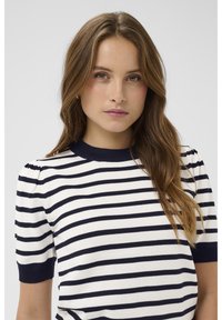 Pasekowy top z krótkim rękawem w granatowe i białe poziome paski, z prążkowanym okrągłym dekoltem i delikatnie bufiastymi rękawami. Miękka faktura materiału.