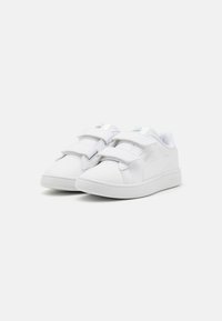Witte sneakers met een gladde leren textuur, twee klittenbandstrips, een gevoerde kraag en een gestructureerde rubberen zool. Logoaccenten aan beide zijden.