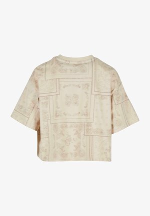 Cropped cream top featuring an all-over paisley and floral pattern in light brown. Short sleeves and a round neckline. Soft fabric texture.