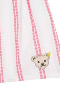 Tela blanca con un patrón de rayas rosas, que presenta un rostro de oso bordado con un detalle amarillo en el lado izquierdo. Material suave y texturizado.