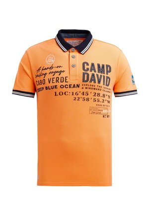 Orangenes Poloshirt mit einem schwarz-weiß gestreiften Kragen. Verfügt über einen dunkelblauen Aufdruck mit Text, darunter "CAMP DAVID" und Koordinaten.