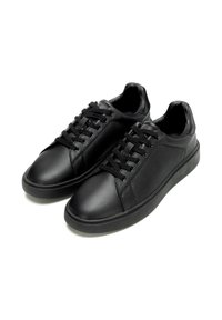 Sneakers neri in pelle con superficie testurizzata, punta tonda, design con lacci e suola piatta in gomma. Senza loghi o decorazioni visibili.