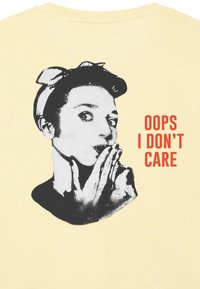 Zwart-wit grafiek van een vrouw met een haarband, speels haar mond bedekkend, naast de tekst "OOPS I DON'T CARE" in vet rood.