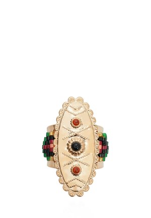 Bague ovale dorée avec des détails décoratifs en perles, une pierre noire centrale et deux pierres rouges, ainsi que des accents multicolores verts, rouges et noirs sur l'anneau.