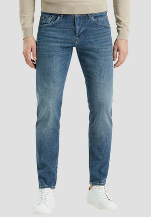 Slim-fit blauwe denim jeans met een lichte vervaging, vijf-pocket ontwerp, en gecombineerd met witte veter sneakers.