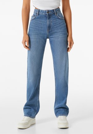 Jean en denim bleu taille haute avec une coupe droite, dotés d'une fermeture à bouton, d'un design à cinq poches et d'une légère décoloration.