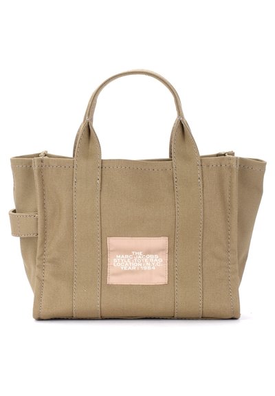 Bolso de tela color caqui con asas cortas, que presenta una etiqueta marrón claro con texto blanco. Diseño sencillo con acentos de costuras verticales.
