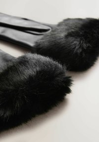 Black leather gloves with a soft, black fur trim at the cuffs, featuring a smooth finish and sleek design.