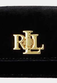 Melnas samta maka ar zelta toņa RL logo sprādzi. Virsma ir ar mīkstu tekstūru, ar kārtīgu šuvumu gar malu.