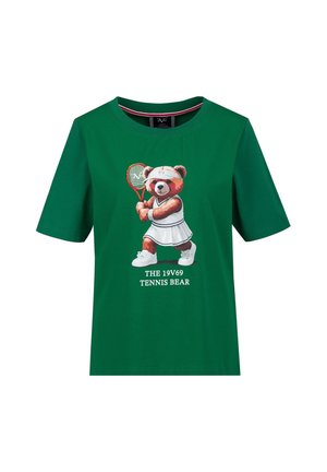 T-shirt vert avec un ours de dessin animé vêtu d'une tenue de tennis blanche tenant une raquette, texte en dessous : "THE 19V69 TENNIS BEAR."