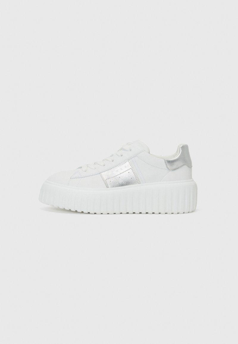 White sneakers with a metallic silver accent, smooth leather material, rounded toe, and a thick, ridged sole.