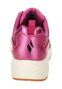 Zapatilla deportiva rosa con acabado brillante, cuello acolchado, media suela blanca y suela de goma texturizada, con detalle del logo en negro.