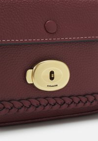 COACH TAB MESS BURNISHED AMBER ONE - Taška cez plece - wine