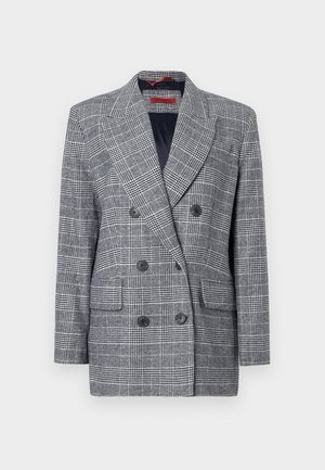 Dubbelzijdige blazer in een zwart-wit geruit patroon, met grote knopen, gelapte revers en opgestikte zakken.