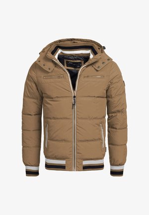 Barna puffertöltetű dzseki kapucnival, elülső cipzárral, csíkozott bordás mandzsettákkal és két cipzáros mellzsebbel. Szövött anyag, amely steppelt textúrával rendelkezik.