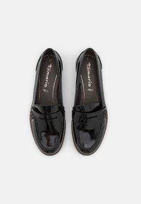 Czarne lakierowane loafersy z zaokrąglonym noskiem, gładką fakturą i ozdobnym paskiem z przodu. Wyposażone w wyściółkę z miękką wkładką dla komfortu.