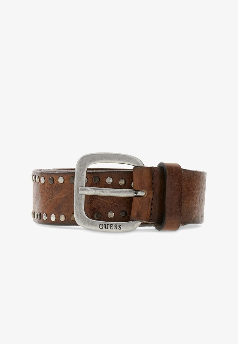 Ceinture en cuir marron avec des clous argentés et une boucle argentée gravée du nom de la marque "GUESS", posée à plat sur un fond blanc.