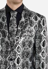 Schwarz-silberne gemusterte Blazerjacke mit Schlangenhaut-Design, ausgestattet mit einer strukturierten Oberfläche, Reverskragen und passender Krawatte.