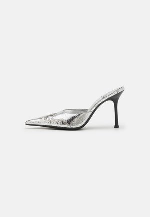 Chaussure à talon aiguille argentée, avec un bout pointu et une finition brillante texturée, dotée d'un talon stiletto noir, présentant des détails subtils et un design à enfiler.