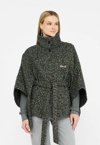 Poncho in houndstooth tessuto intrecciato nero e grigio, con colletto alto, chiusura a bottone e cintura in tessuto, caratterizzato da una finitura morbida.