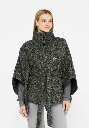 Tkaný pončo s vzorom houndstooth v čiernej a sivej farbe, s vysokým golierom, zapínaním na gombíky a textilným opaskom, s jemne štruktúrovaným povrchom.