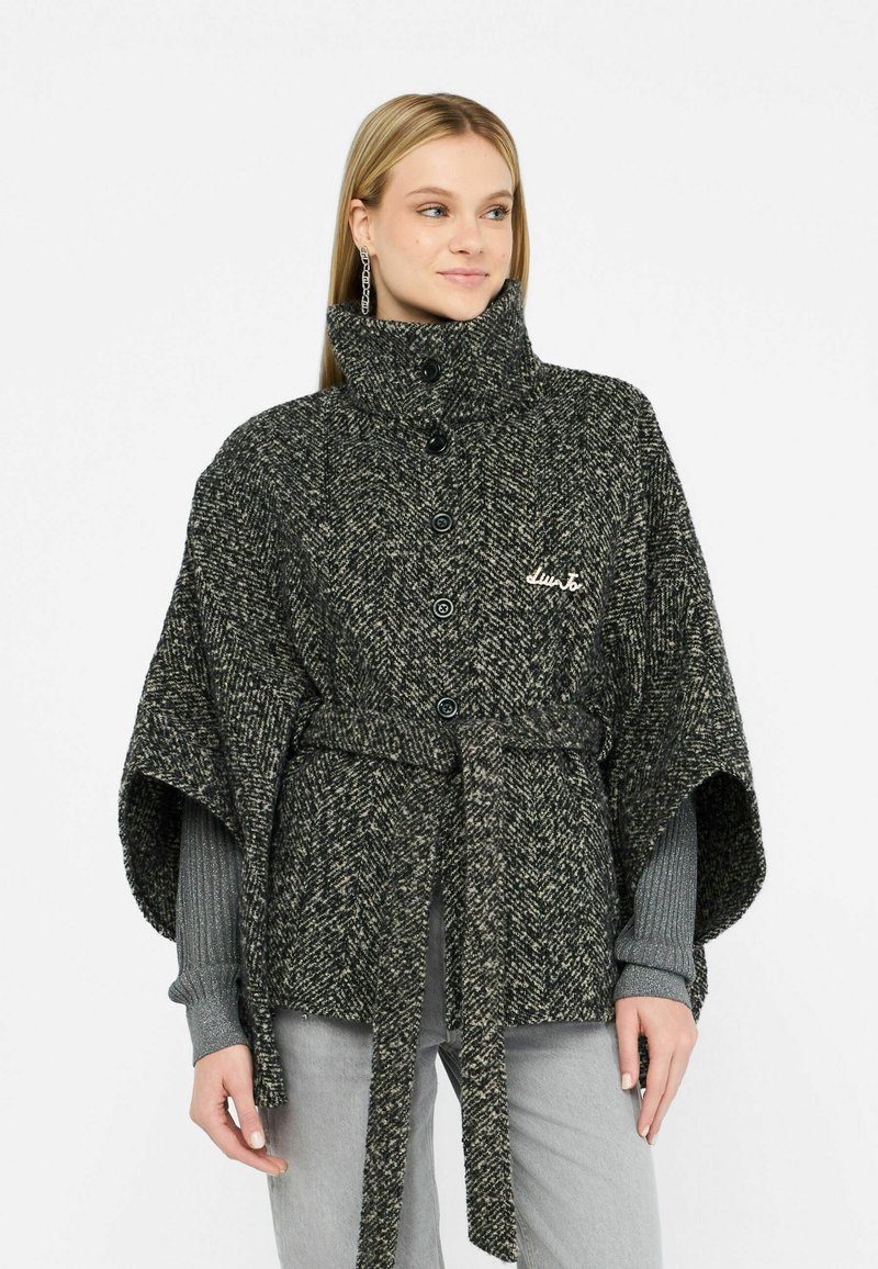Poncho in houndstooth tessuto intrecciato nero e grigio, con colletto alto, chiusura a bottone e cintura in tessuto, caratterizzato da una finitura morbida.