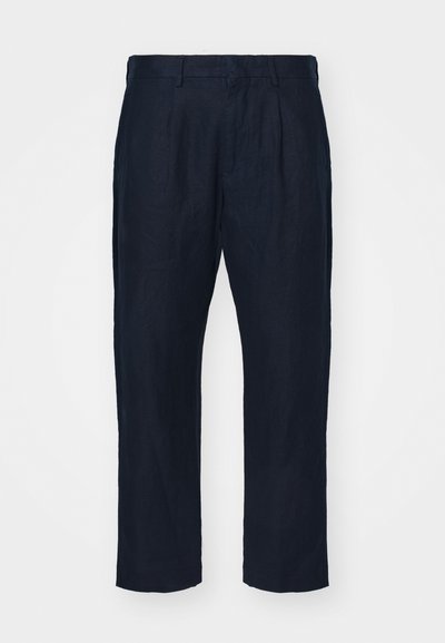 Námořnické lněné kalhoty s rovnými nohavicemi, které mají záševky vpředu a hladkou texturu. Obsahují poutka na pás a boční kapsy.